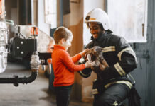 Comment initier les enfants de CP à la découverte des métiers ? pompier uniforme homme se prépare travailler guy enfant