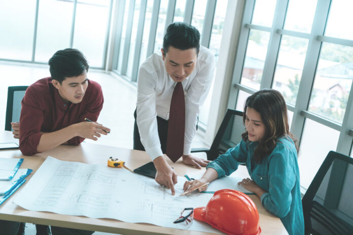 Construction Boss with business man engineer and architect is discussing on working table with building plan construction boss with business man engineer and architect is discussing on working table with building plan